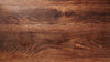 Close up of the top of a dark wood table, showing the wood grain. 
