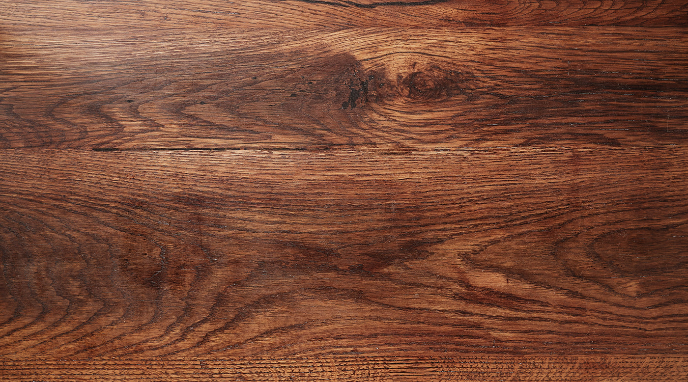 Close up of the top of a dark wood table, showing the wood grain. 
